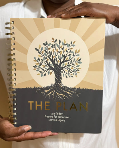 Planner titled 'The Plan' held by a person with a tree design on the cover.